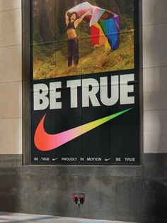 there is a poster on the side of a building that says be true with a man holding a kite