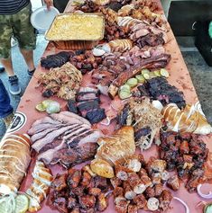 a long table covered with lots of different types of meats and other food items