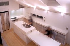 a blurry photo of a kitchen with white countertops and stainless steel refrigerators