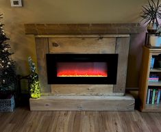 an electric fireplace in a living room next to a christmas tree