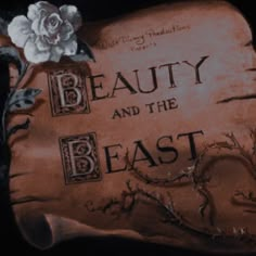 a sign that says beauty and the beast with a rose on it's side