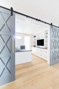 an open door leading to a living room with white cabinets and wood flooring in it