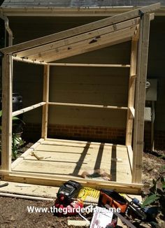 an unfinished bed frame is being built in the yard with tools and construction supplies around it