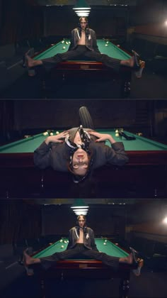 a man laying on top of a pool table in front of a green billiard