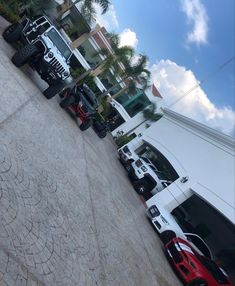 a row of trucks parked next to each other on the side of a road in front of a building