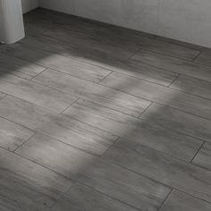 a white toilet sitting on top of a wooden floor