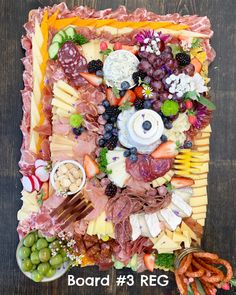 a platter filled with assorted meats, cheeses and vegetables on top of a wooden table