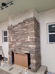 a brick fireplace is being built in the corner of a room with no one around it