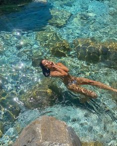 a woman is floating in the clear blue water