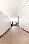 an empty hallway with white walls and wooden floors