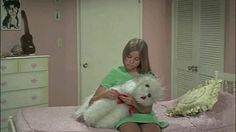 a woman sitting on top of a bed holding a white teddy bear in her arms