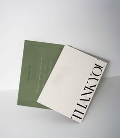 two books sitting next to each other on top of a white tablecloth covered surface