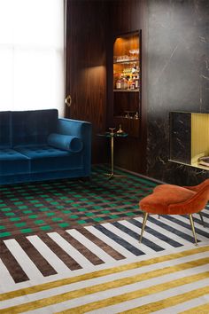 a living room filled with furniture and a colorful rug on top of a wooden floor