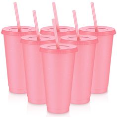 six pink plastic cups with straws in them are lined up against a white background