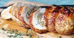 sliced chicken on a cutting board with herbs