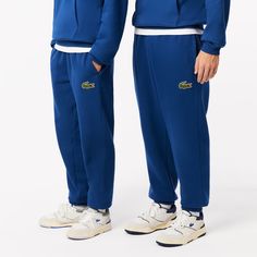 A lesson in French chic on the move: these Lacoste sweat pants are made from a warm, thick, super-soft fleece fabric. Inspired by training kits, with stylish streetwear-inspired touches. An adjustable, practical, contemporary piece. Casual Fleece Tracksuit With Pockets, Sporty Fleece Tracksuit For Loungewear, Fleece Athleisure Tracksuit For Leisure, Sporty Streetwear Bottoms With Logo Detail, Sporty Fleece Sweatpants For Loungewear, Casual Moisture-wicking Sweatpants For Loungewear, Athleisure Tracksuit With Elastic Waistband For Winter, Winter Fleece Joggers In Athleisure Style, Winter Athleisure Tracksuit With Elastic Waistband