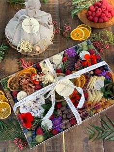 an assortment of fruits and cheeses in a box on a wooden table next to other fruit