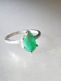 Imperfectly Perfect! This emerald came from a huge lot acquired in the late 70s. The natural inclusions in this stone along with the faceting on the back of the emerald make this ring so unique. This natural 1.56ct emerald is pear shaped cut and pavilion set (back of the stone is set face up). There is a natural clarity characteristic towards the lower tip of pear. Sterling silver mounting has five prongs and a v tip to protect the point of pear. High polished finish band tapers from 1.7 to 1.5 Emerald Solitaire Ring, Aquamarine Solitaire Ring, Aquamarine Studs, Imperfectly Perfect, Ruby Diamond Rings, Silver Prices, Sterling Silver Bands, How To Make Earrings, Ring Sterling Silver