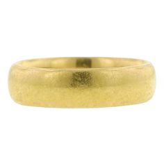 a yellow gold wedding ring on a white background