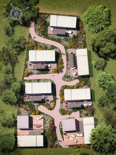 an aerial view of several buildings in the middle of a field with trees and grass