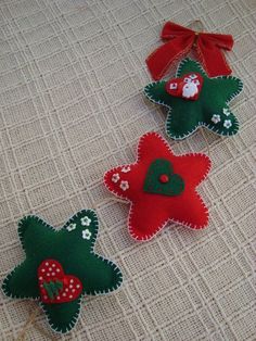 three felt christmas tree ornaments on a table