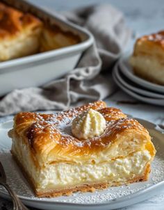 a piece of pastry on a plate with a fork and bowl in the back ground