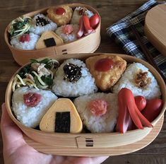 someone is holding a bento box filled with sushi and other food items in it