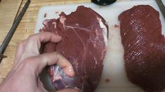 two pieces of meat being prepared on a cutting board