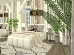 a white bed sitting next to a tall plant in a living room filled with furniture