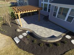 an outdoor patio with a pergolated walkway and stone pavers in the foreground