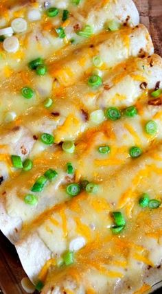 an enchilada covered in cheese and green onions