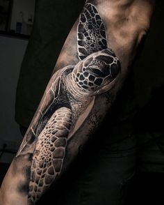 a man's arm with a turtle tattoo on it