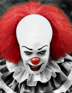 a creepy clown with red hair and white face