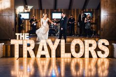 a bride and groom dancing on the dance floor at their wedding reception in front of the word, the trayors