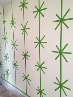 the wall is painted green and has snowflakes on it, as well as lines