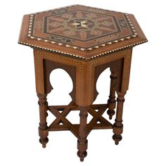 an octagonal wooden table with intricate carvings on the top and sides, inlaid with geometric designs