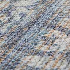 a close up view of the texture of a rug with blue, brown and white colors