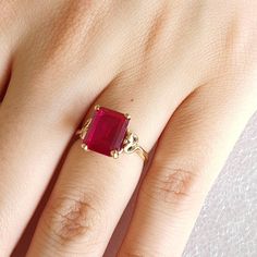 Gold and simulated red Ruby ring.   Ring is made with 9 carat yellow gold.  Simulated red Ruby is Emerald cut and measures 10mmsx8mms. Ring size is L (Australian size) or 5 1/2 (US size). Ring is ready to ship in 1-2 working days.  We resize free of charge.  Please allow a couple of additional days for resizing. This ring can be custom made to your specification.  Contact us with your queries. All my rings come in a velvet ring box. Anniversary Ruby Crystal Ring In Yellow Gold, Anniversary Yellow Gold Ruby Crystal Ring, 14k Gold Red Ruby Ring Fine Jewelry, Classic Promise Ring With Lab-created Ruby, Gold Ruby Rings With Diamond Cut, Emerald Cut Ruby Ring With Diamond Details, Yellow Gold Ring With Lab-created Ruby, Elegant Gold Crystal Ring With Ruby, Formal Yellow Gold Rings With Ruby