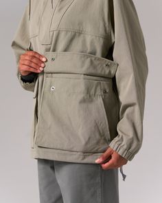 The Takibi Ripstop Anorak is a durable, fire-resistant hooded jacket. The anorak features two large flap pockets on the front, drawcords at the hood and hem, a covered half zipper on the front, and a zipper on the left side for easy on and off. Additional features include hand warmer pockets, an accessory loop on the right breast, ventilated panels on the back, and elastic cuffs. The material is an aramid-cotton blend with ripstop stitching throughout for fire resistance and durability. Functional Track Jacket With Side Pockets For Outdoor, Functional Outdoor Track Jacket With Side Pockets, Functional Track Jacket With Pockets For Outdoor Activities, Functional Nylon Parka With Cargo Pockets, Utility Nylon Parka With Side Pockets, Hooded Khaki Track Jacket With Pockets, Khaki Hooded Track Jacket With Pockets, Nylon Utility Parka With Cargo Pockets, Utility Nylon Parka With Cargo Pockets