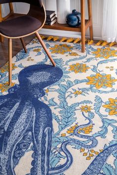 an octopus rug is shown on the floor in front of a chair and table with two chairs