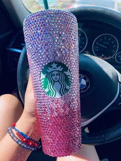 a starbucks cup is decorated with swaroons and beads