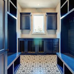 an empty room with blue cabinets and tile flooring on the walls, along with a window