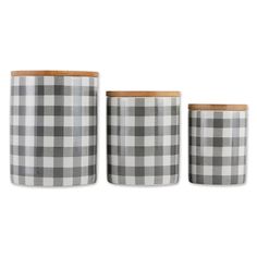 three black and white plaid canisters with wooden lids