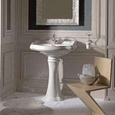 a white pedestal sink sitting under a mirror