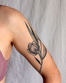 a woman's arm with a flower tattoo on the left side of her body