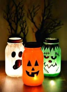 three mason jars decorated with halloween pumpkins and jack - o'- lantern faces