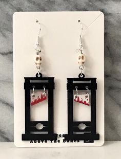 Step into the spooky season with these Handmade Halloween Earrings! Each pair is meticulously crafted with attention to detail, featuring an array of Macabre, Gothic, and Halloween designs. From skulls and skeletons to spiders and spider webs, these earrings showcase a range of eerie elements like ghosts, coffins, crosses, witch hats, and even guillotines. Perfect for expressing your Halloween spirit or adding a touch of everyday Gothic aesthetic, these earrings are sure to make a statement. Mad Edgy Pierced Earrings For Halloween, Edgy Adjustable Earrings For Halloween, Edgy Handmade Earrings For Halloween, Edgy Pierced Halloween Earrings, Edgy Halloween Pierced Earrings, Edgy Dangle Earrings For Halloween, Edgy Handmade Halloween Earrings, Halloween Fantasy Dangle Earrings, Guillotine Earrings