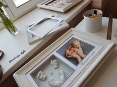 two framed pictures sitting on top of a table