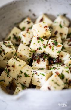 a white bowl filled with tofu and seasoning sitting on top of a table