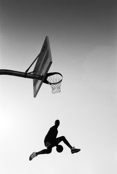 a man jumping up into the air with a basketball in front of him and an object flying through the air